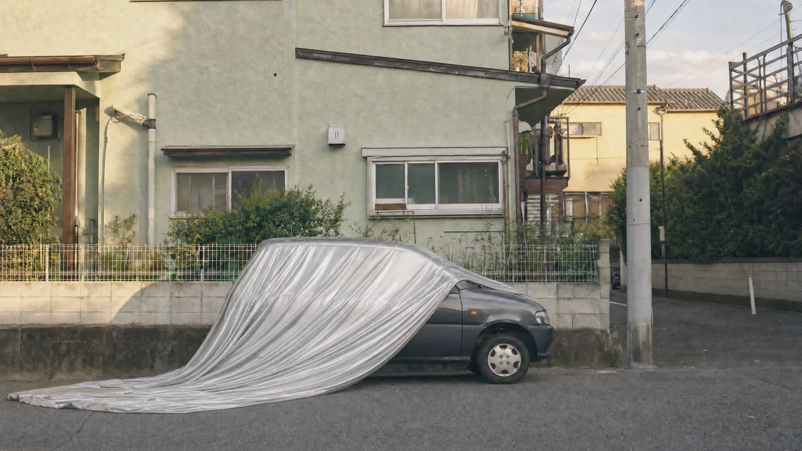 Silver fabric draped over a parked car